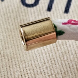 Close-up of the gold-tone barrel clasp on the white Monogram Multicolor Confidential Bracelet