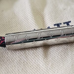 Louis Vuitton monogram engraving on the silver-tone clasp of the black Confidential Bracelet