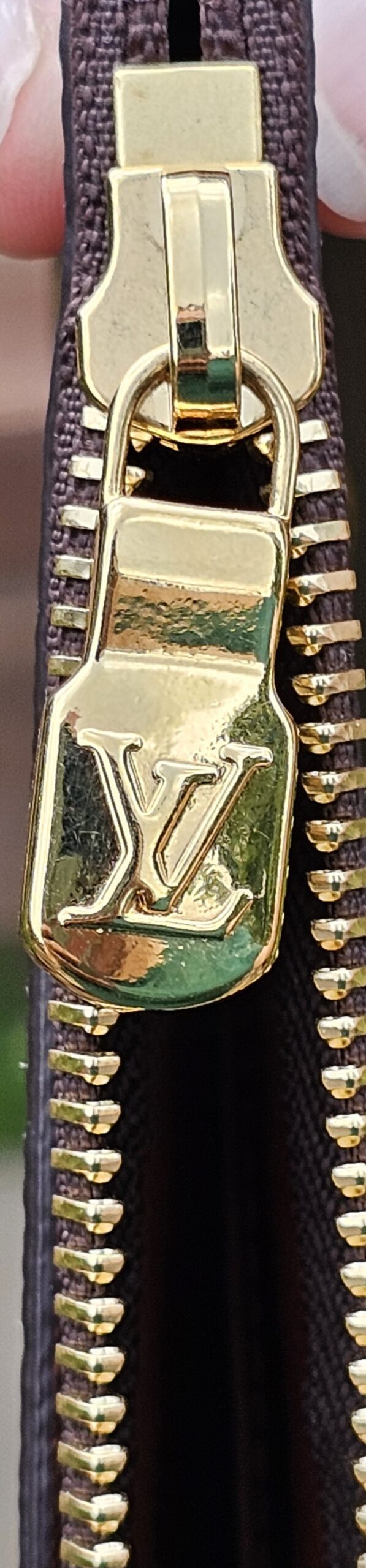 Close-up of the gold-tone zipper and LV pull on the Monogram Key Pouch M