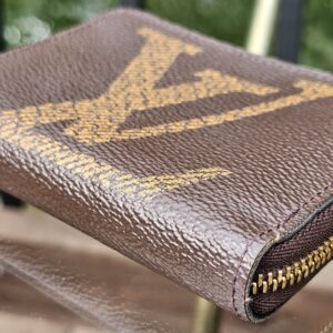 Corner of the Monogram Giant Zippy Coin Purse with light rubbing to the canvas