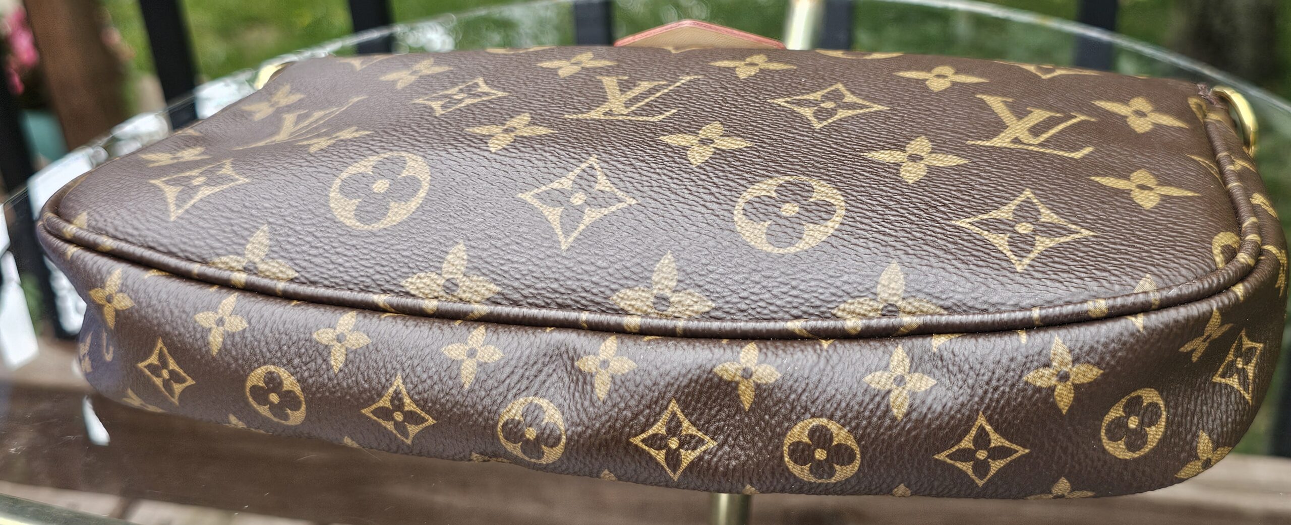 Top edge of the Monogram large pochette showing the zip and canvas condition
