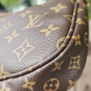 Corner of the Monogram large pochette showing clean piping and canvas