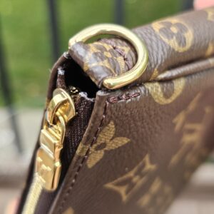 Gold-tone D-ring and zip hardware on the Monogram large pochette