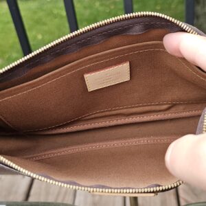 Monogram large pochette held open to show the clean brown interior