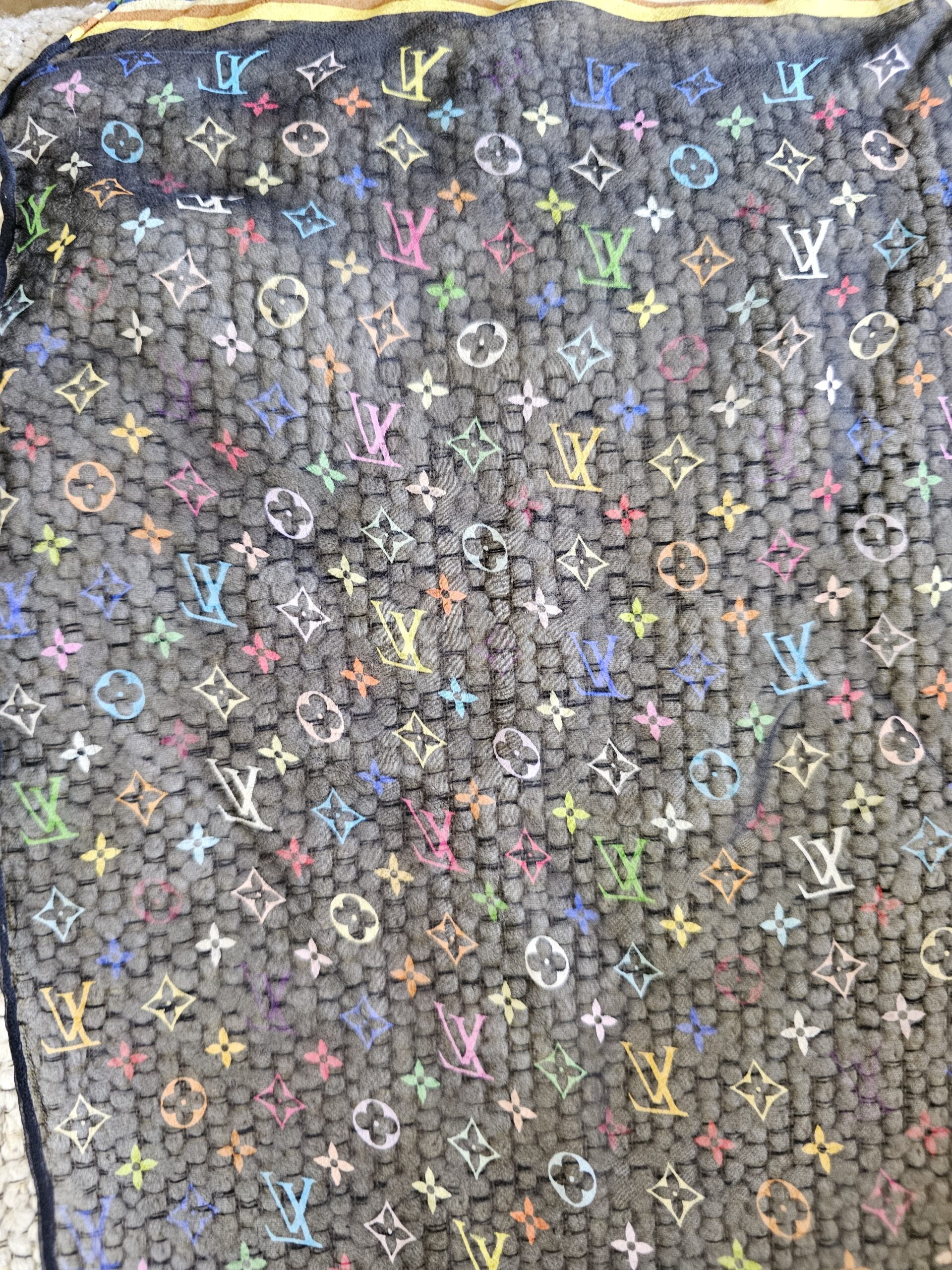 Close-up of the colorful Monogram initials and flowers on sheer black crepe silk