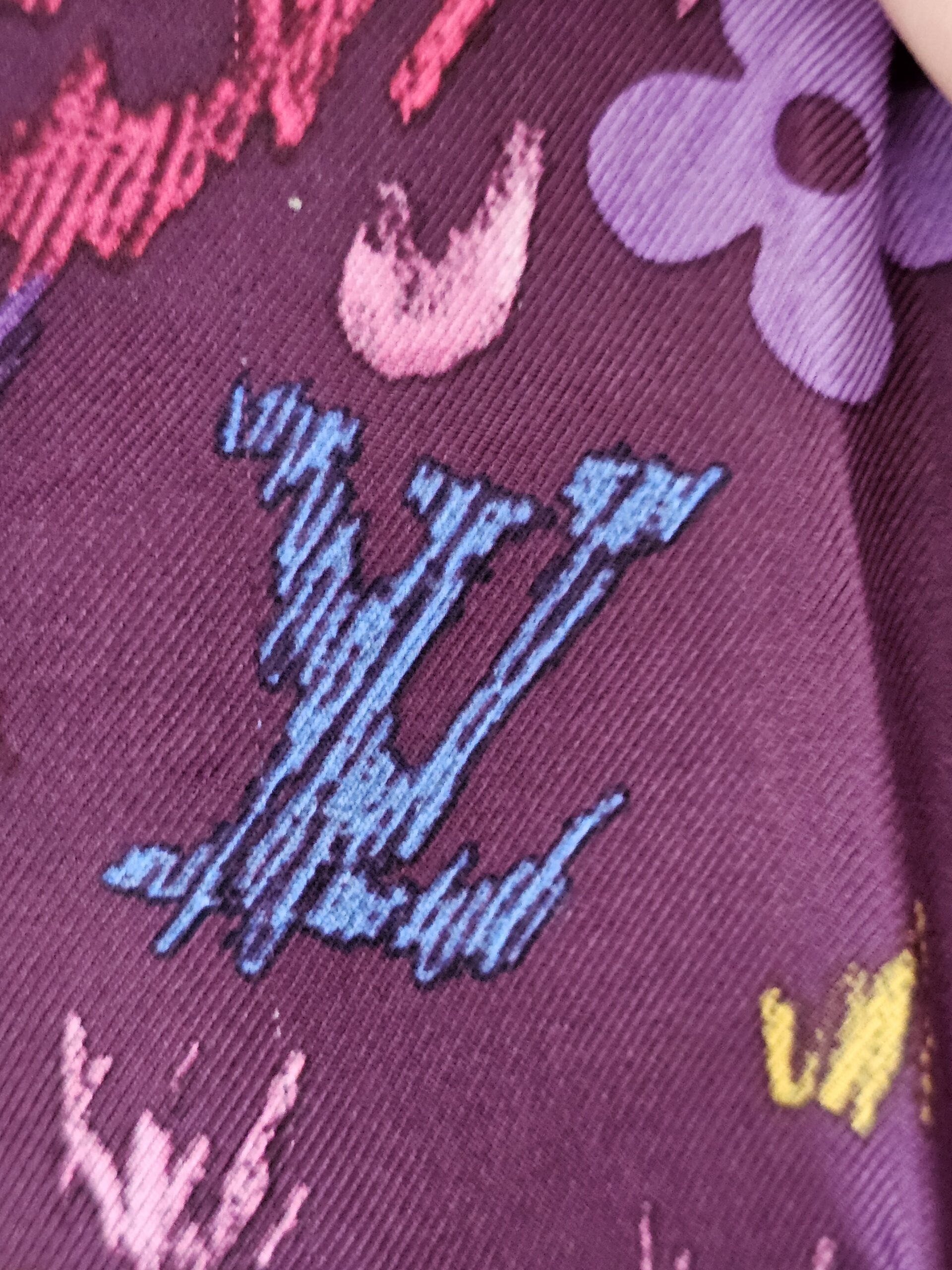 Blue painted LV initials among the Monogram flowers on the silk scarf