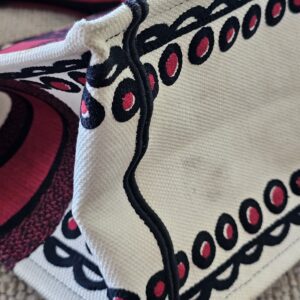 Corner of the Dioramour Book Tote showing light discoloration on the white embroidery