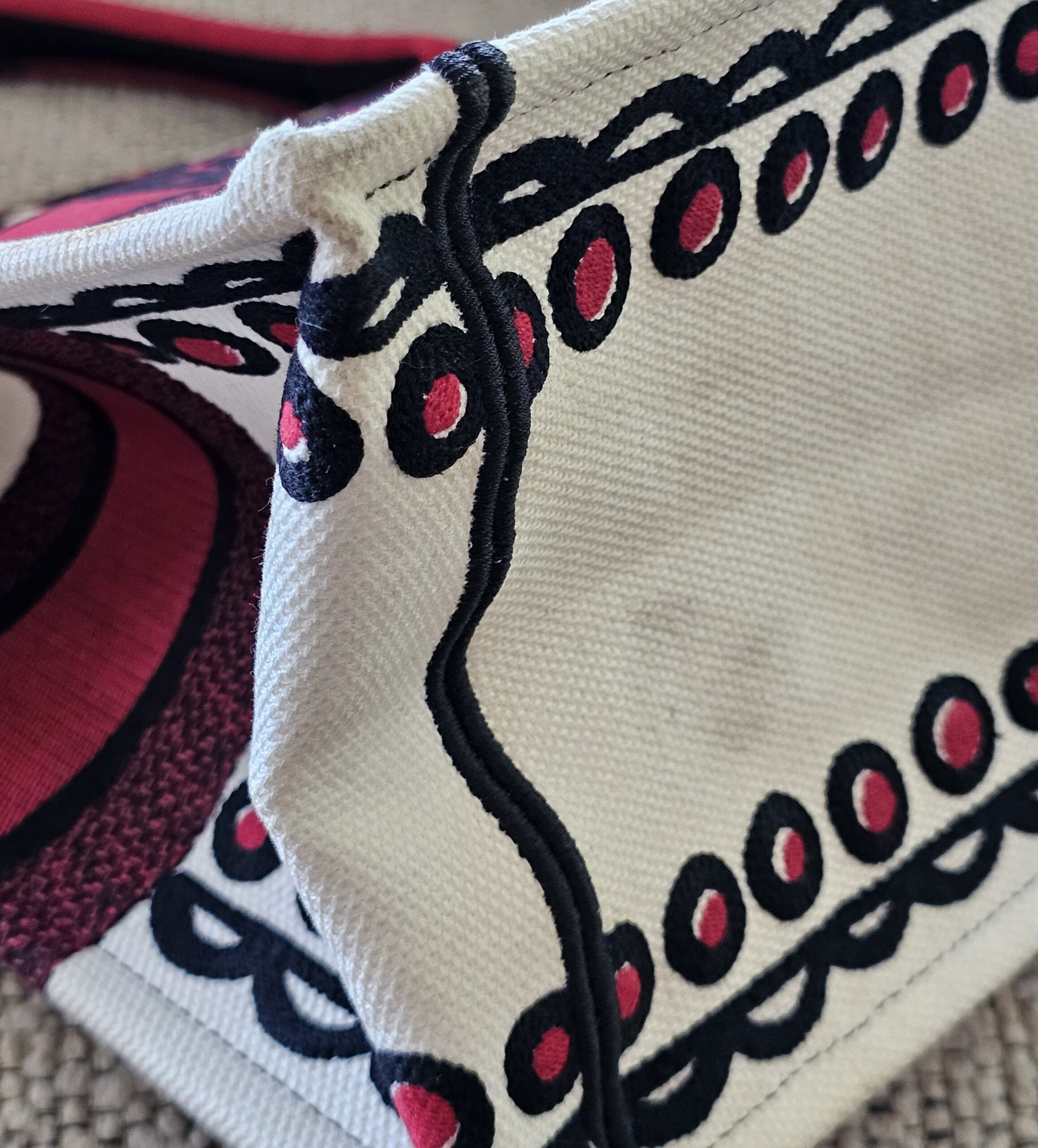 Corner of the Dioramour Book Tote showing light discoloration on the white embroidery