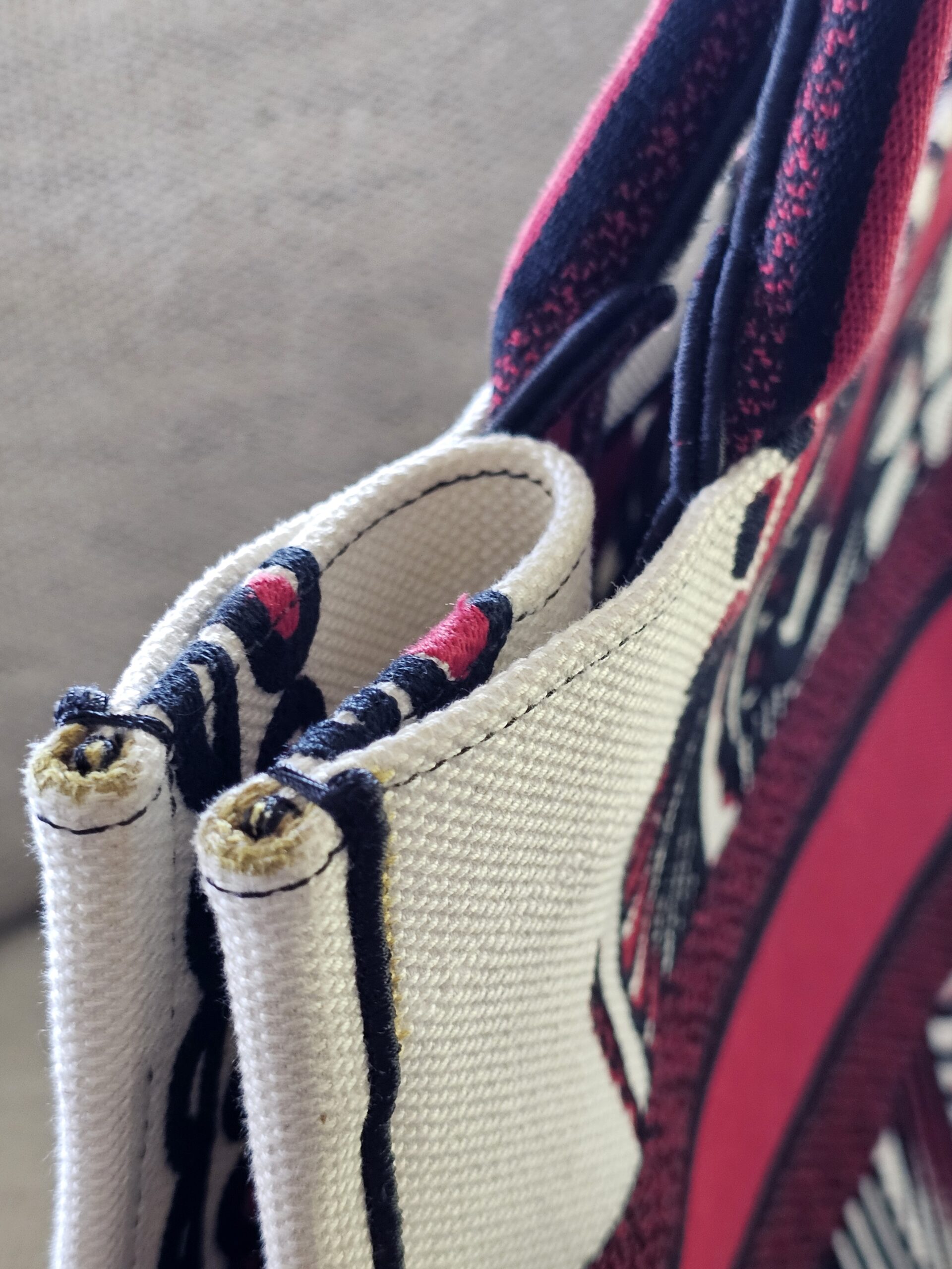 Top edge and handle area of the Christian Dior Book Tote showing fuzzing