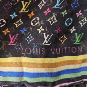 LOUIS VUITTON lettering above the multicolor striped border of the crepe scarf