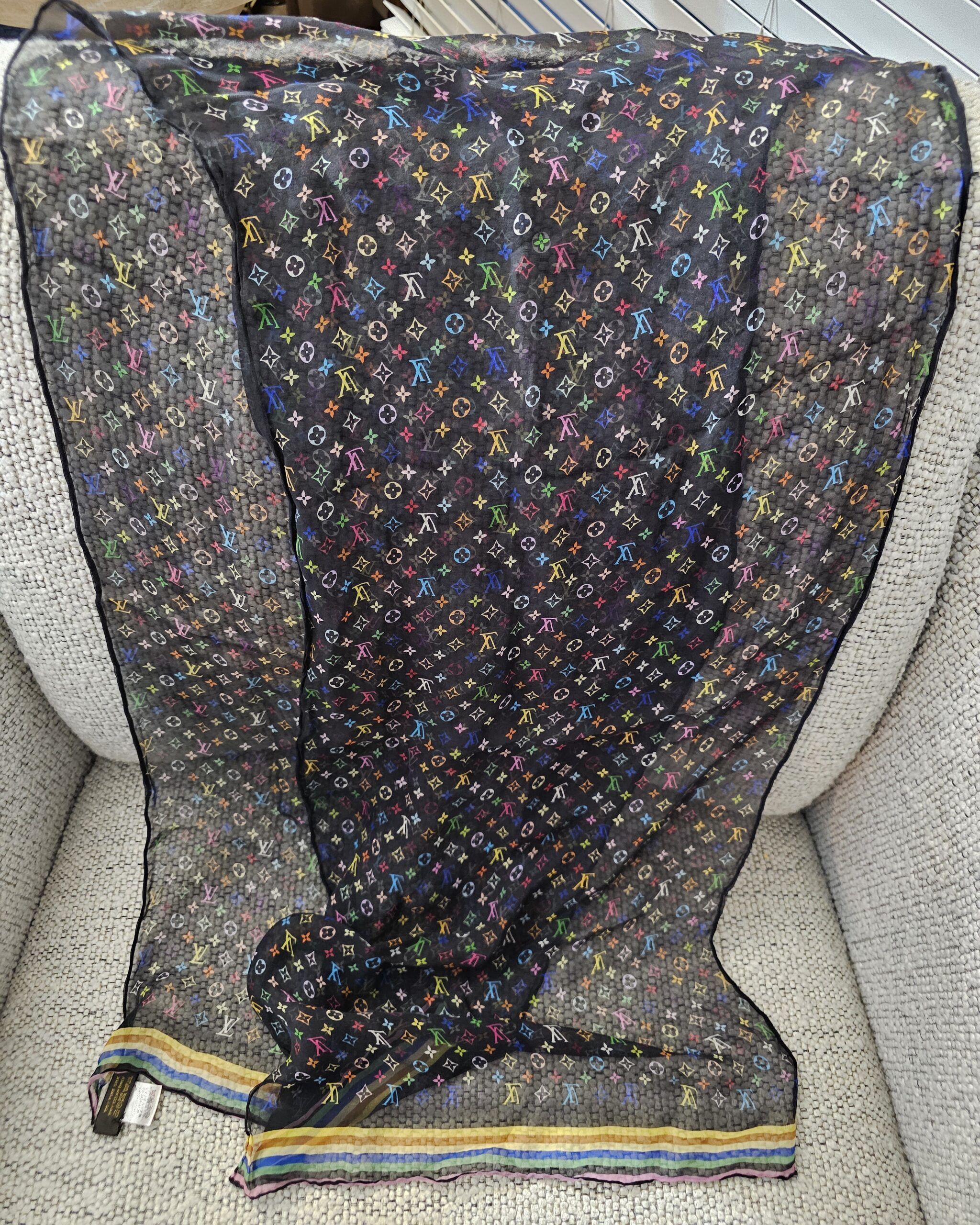 Sheer black Monogram Multicolor crepe scarf spread across a chair