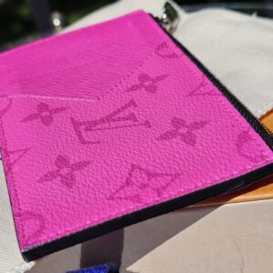 Front of the fuchsia Taigarama card holder resting on its dust bag