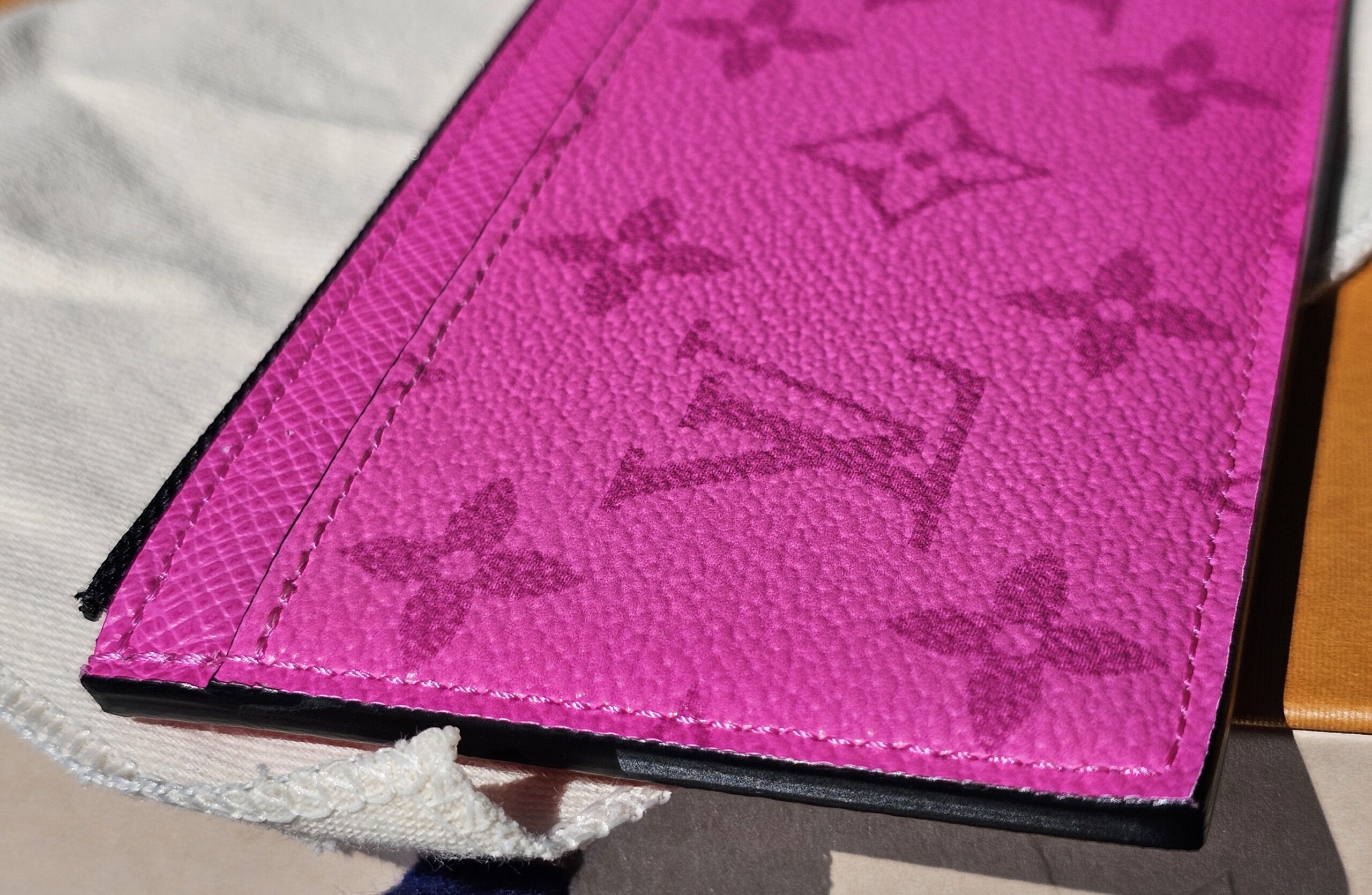 Close-up of the embossed Monogram on fuchsia Taiga leather