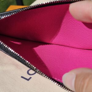 Zip coin compartment of the fuchsia card holder held open