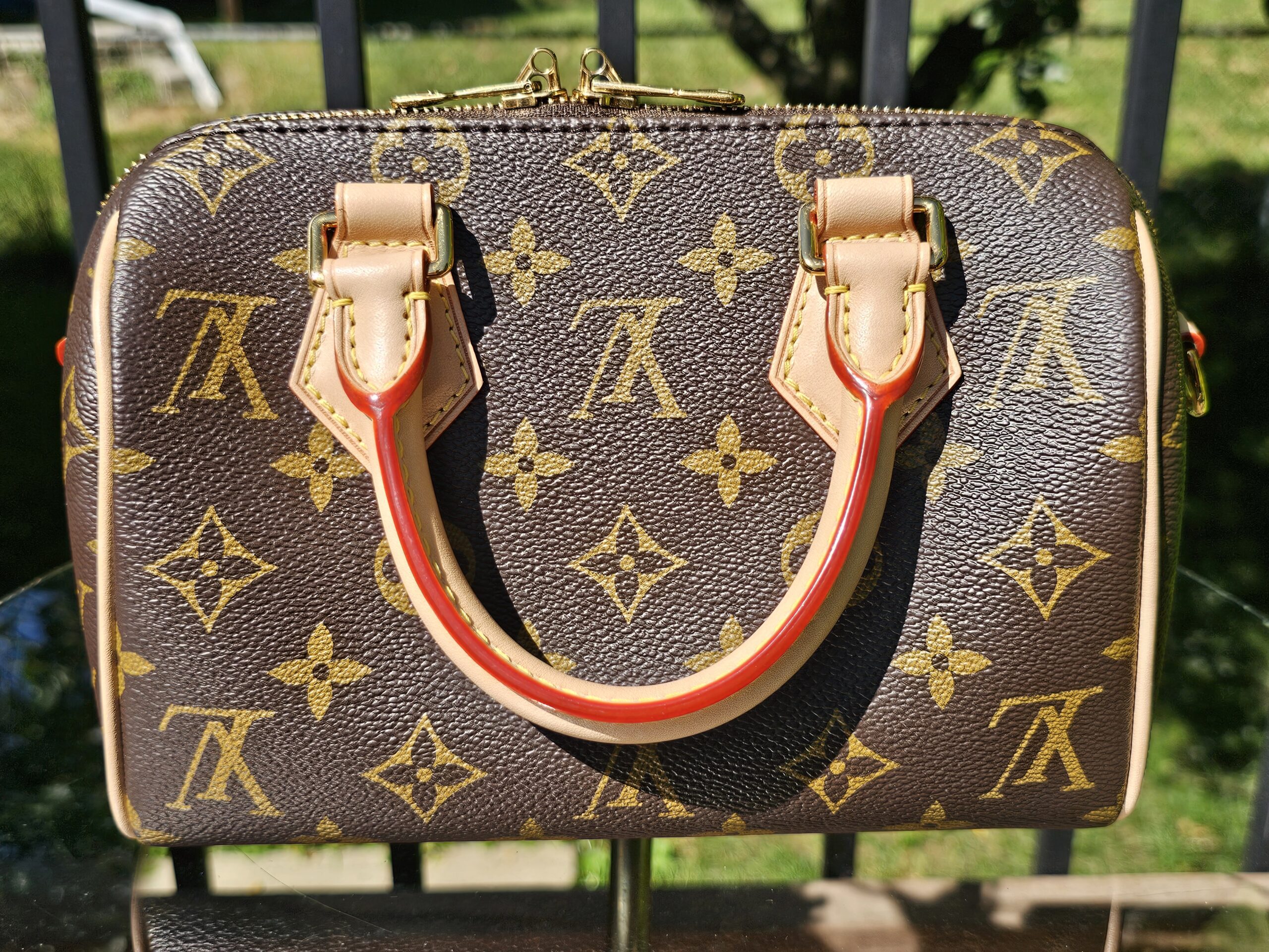 Side of the Speedy Bandouliere 20 with the vachetta handle and red trim