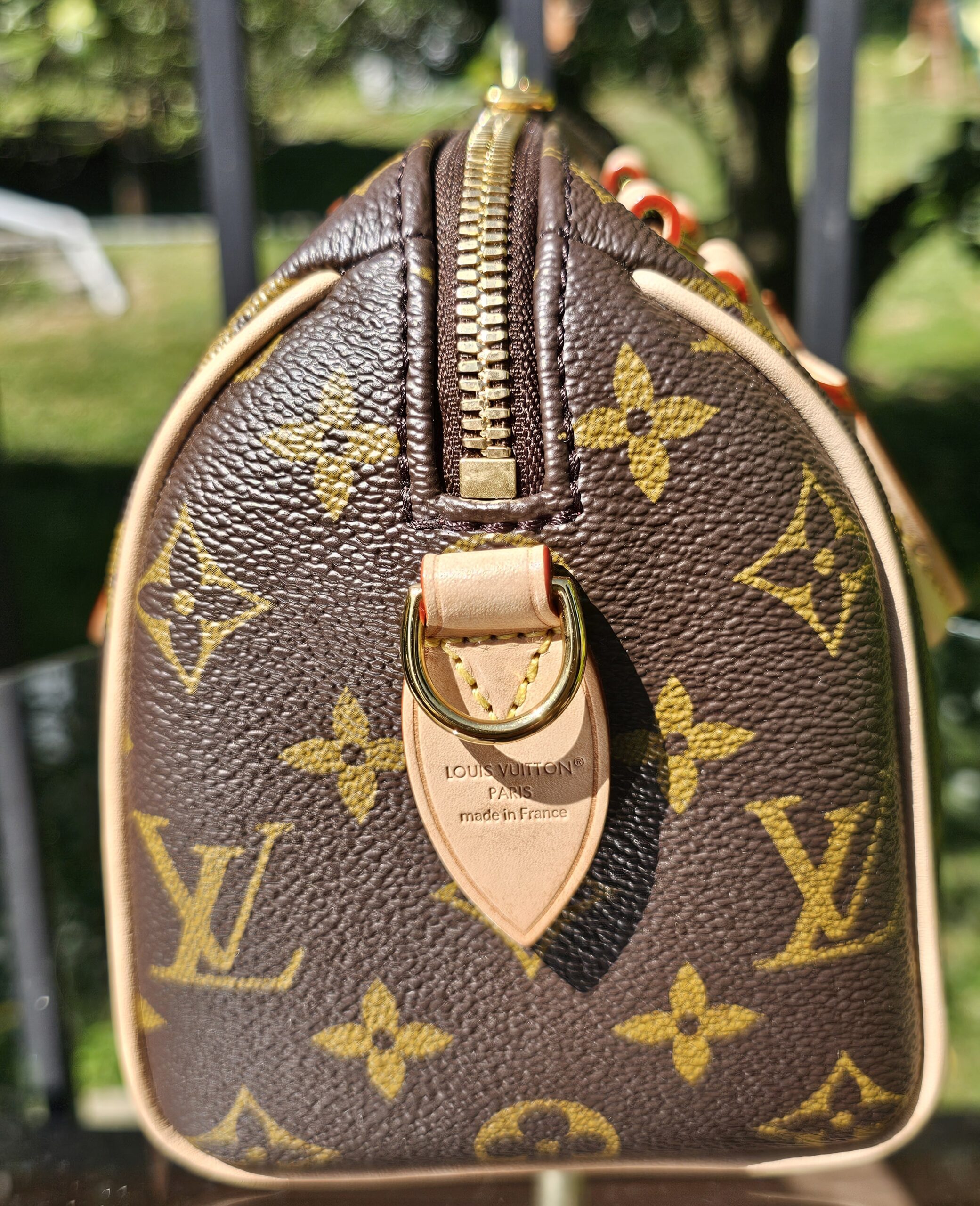 Top zip and leather tab of the Monogram Speedy Bandouliere 20