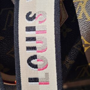 LOUIS VUITTON printed in pink on the cream shoulder strap
