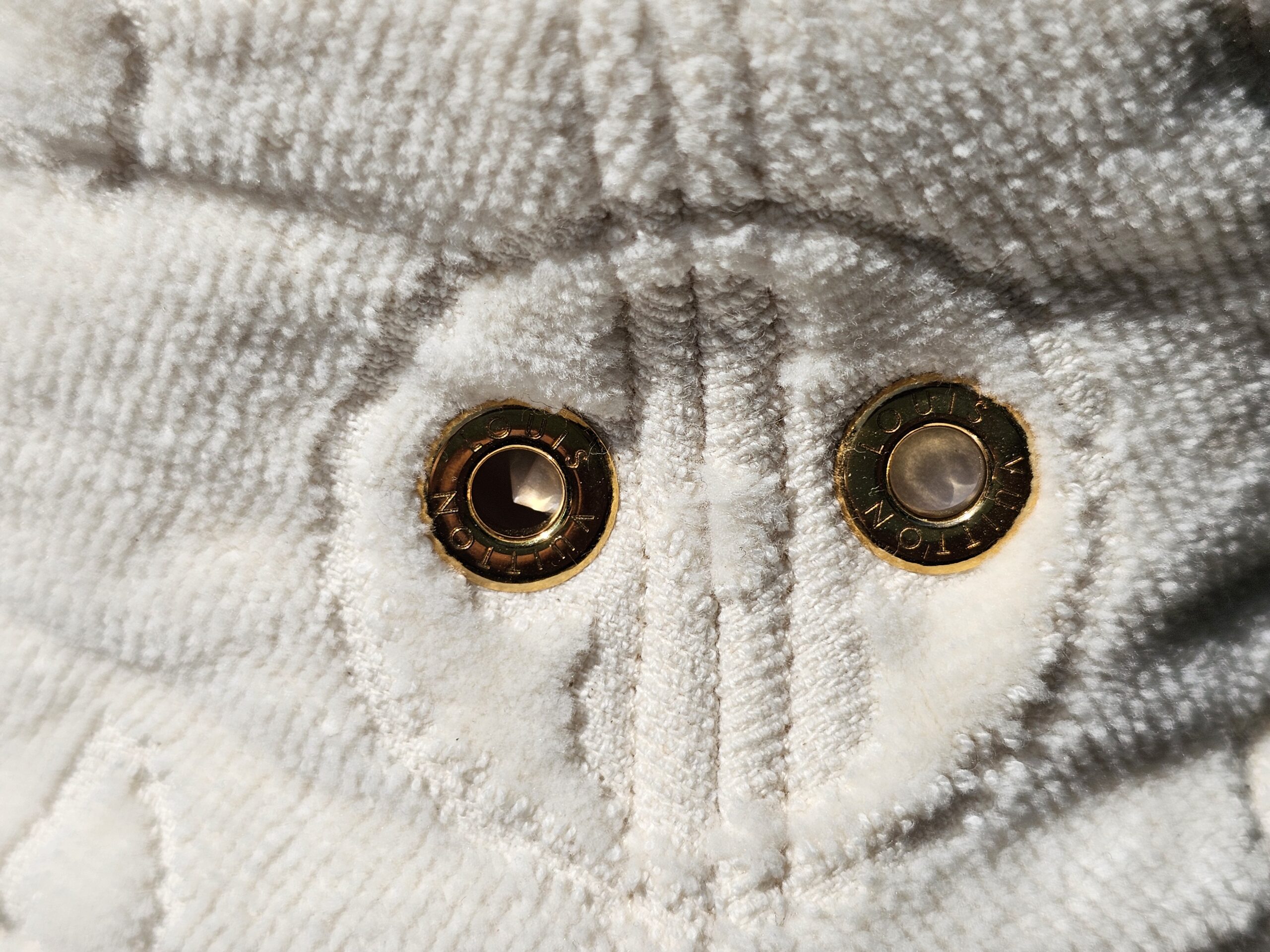 Close-up of the engraved gold-tone eyelets