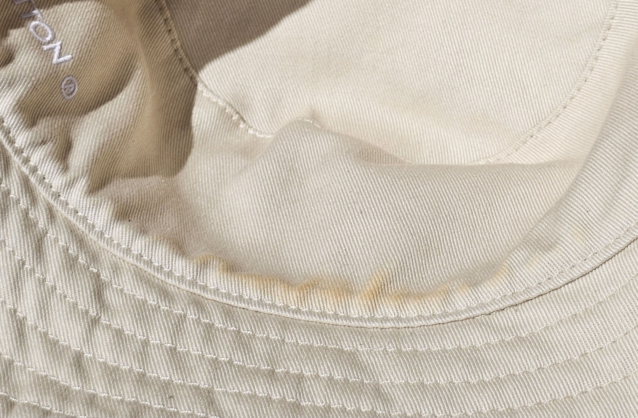 Smooth cream cotton reverse with light discoloration near the brim