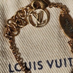 Circle charm and LV medallion on the gold-tone chain