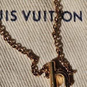 Letter H charm hanging from the gold-tone chain
