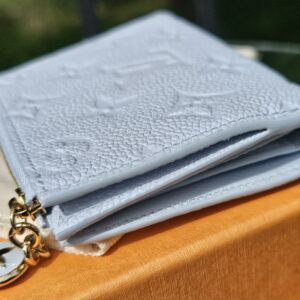 Lisa Wallet resting on its box showing the zip coin compartment and flower charm