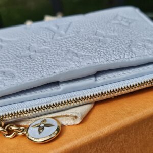 Zip coin compartment and gold-tone Monogram flower charm on the Lisa Wallet