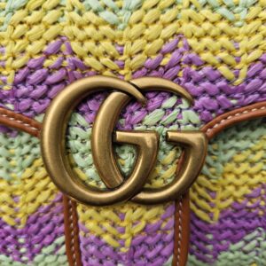 Aged gold Double G hardware on the woven raffia flap