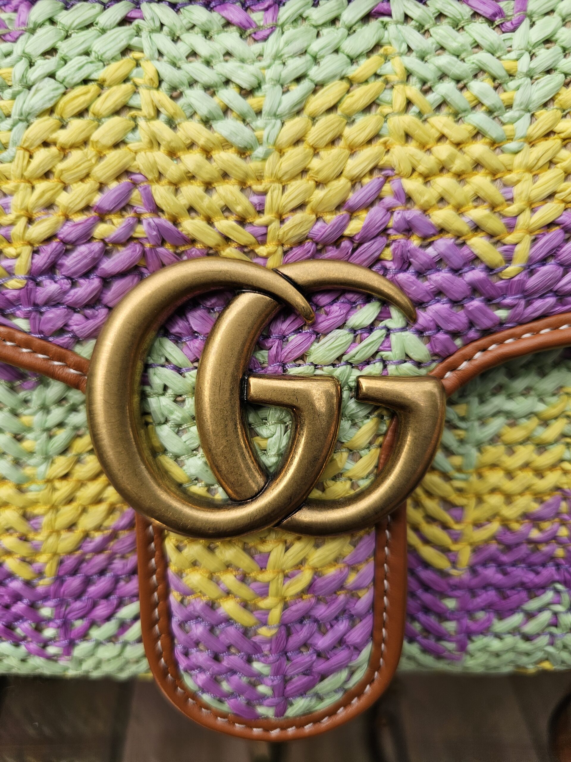Aged gold Double G hardware on the woven raffia flap