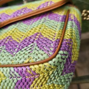 Angled view of the raffia Marmont with tan leather trim