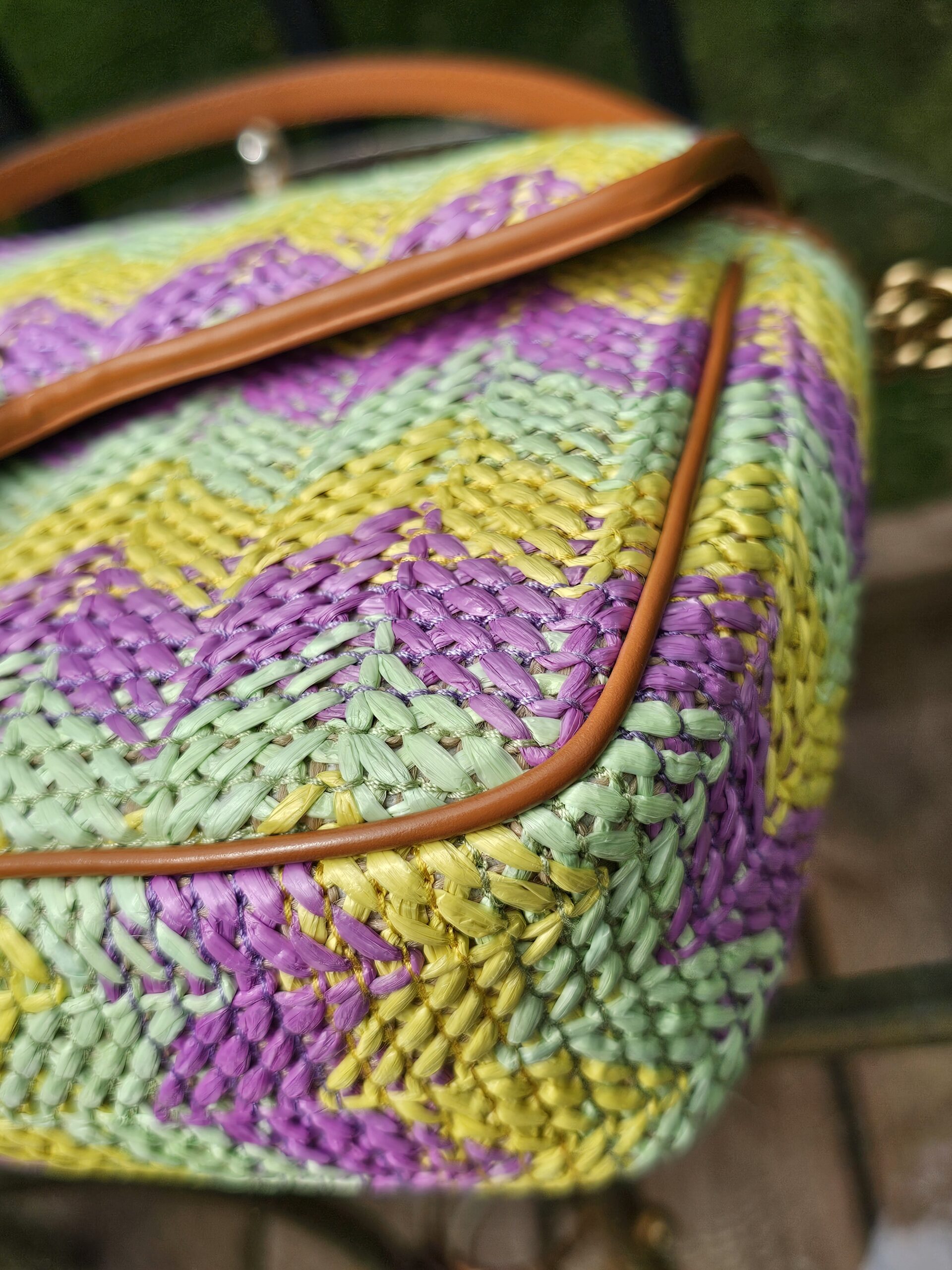Angled view of the raffia Marmont with tan leather trim
