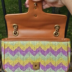 Flap lifted to show the tan leather underside and chain attachment