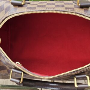 Speedy Bandouliere 30 held open to show the red interior