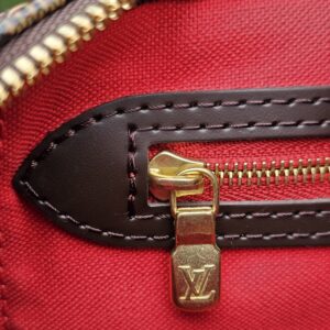 Gold-tone LV zipper pull against the red lining