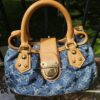 Louis Vuitton Monogram Denim Pleaty Blue - front view with the gold-tone push lock and vachetta trim