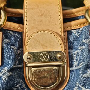 Vachetta flap and gold-tone push lock on the Pleaty