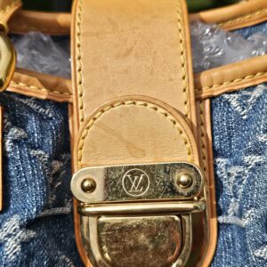 Gold-tone push lock closure with light wear