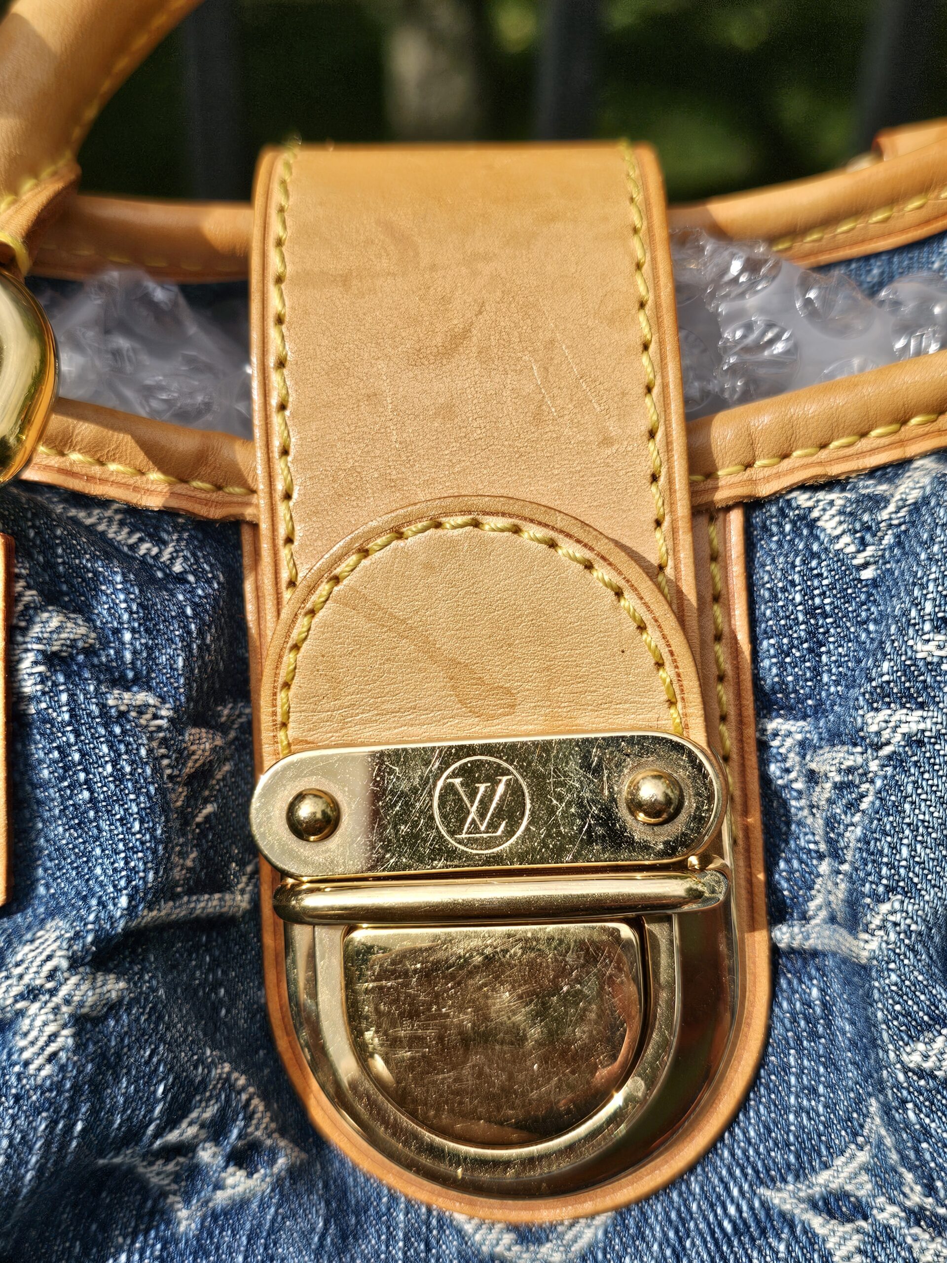 Gold-tone push lock closure with light wear