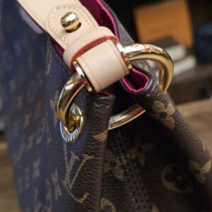 Gold-tone ring joining the vachetta strap to the bag