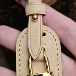 Gold-tone Louis Vuitton padlock on its vachetta tab