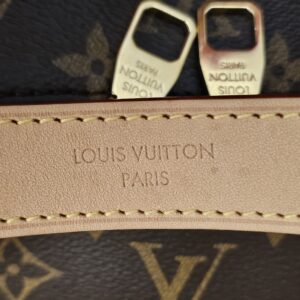 LOUIS VUITTON PARIS heat stamp on the vachetta trim beside the zip pulls