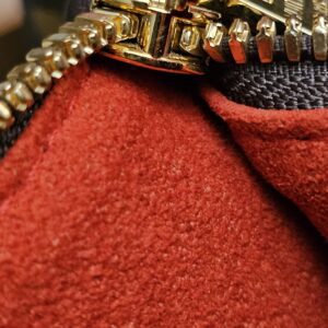 End of the gold-tone zip against the red lining