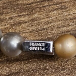 Small silver tag stamped FRANCE and GP0114 between the beads