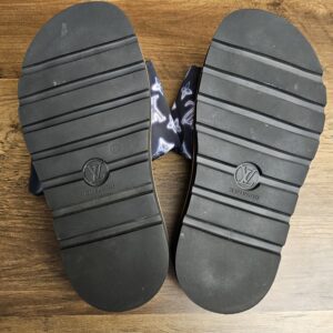 Rubber outsoles of both mules showing light wear