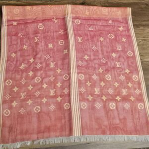 Coral pink section of the stole laid flat with the striped border