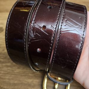 Embossed Monogram in the Amarante Vernis held in hand
