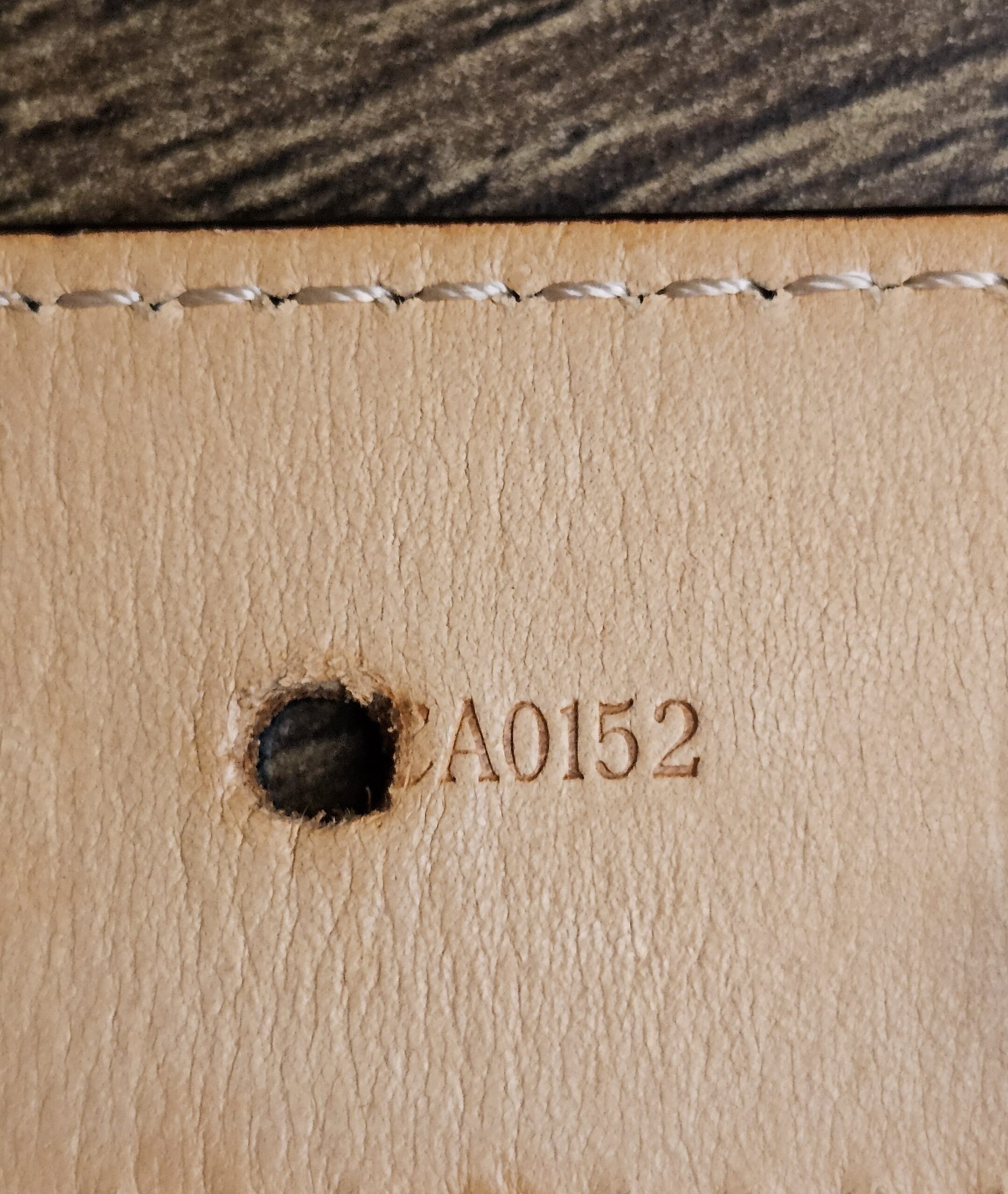 Date code CA0152 stamped beside a belt hole