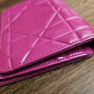 Hot pink patent wallet seen from the side at an angle