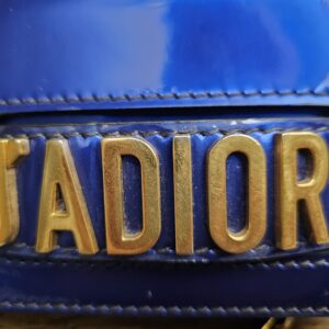 Close-up of the antiqued gold-tone J'ADIOR lettering on the flap