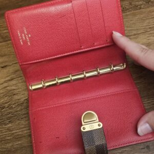Agenda opened to show the six-ring mechanism and card slots in red leather